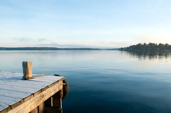 A small wooden dock on a lake at dawn.